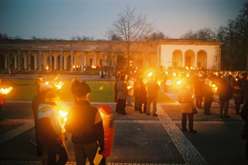 Weihnachtsfeier auf dem Friedhof am Hörnli, Kappellenplatz, die Teilnehmenden halten Kerzen oder Fackeln