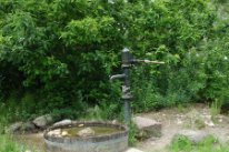 Die Wasserstelle mit der Schwengelpumpe speist einen Wasserlauf.